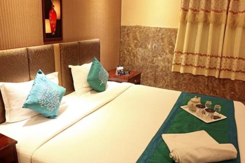 SaluaSHREE KRISHNA HOTELS & RESORTS PVT LTD的酒店客房配有一张带蓝色枕头的大床