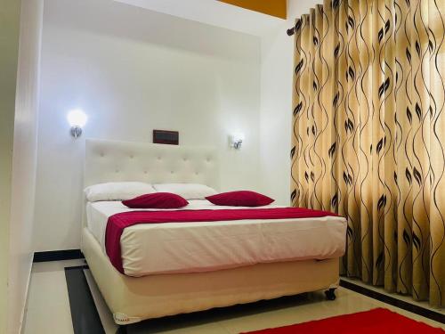 丹不拉Laaya Neem Dambulla的一间卧室配有一张带红色枕头的床