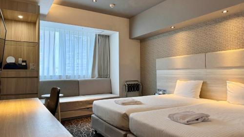 那霸Hotel Aqua Citta Naha的酒店客房设有两张床和窗户。
