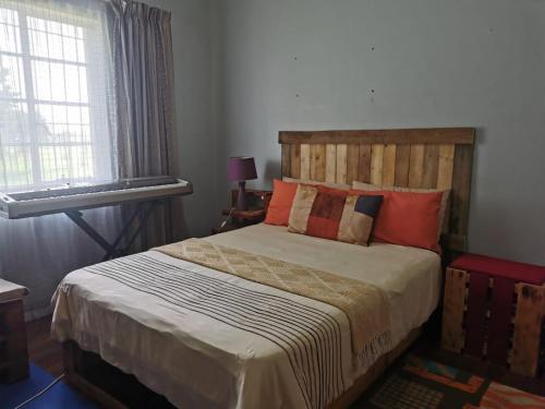 BrakpanGarden View Home的一间卧室配有一张带木制床头板的床