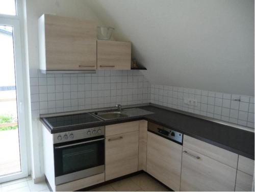 塞巴特阿尔贝克Ferienwohnung Ida的厨房配有水槽和炉灶 顶部烤箱