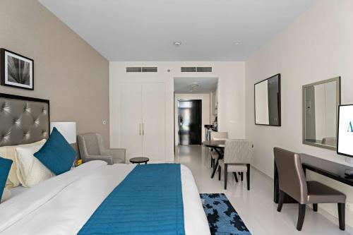 迪拜Aliving Elite Studio Celestia A Dubai South的酒店客房设有一张大床和一张书桌。