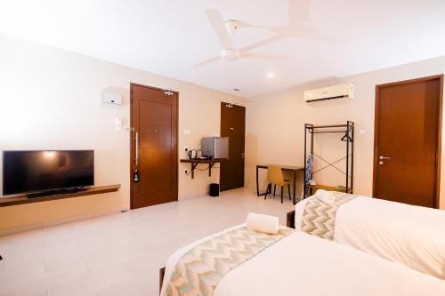 瓜埠Rebungan Resort Langkawi的配有一张床和一台平面电视的酒店客房