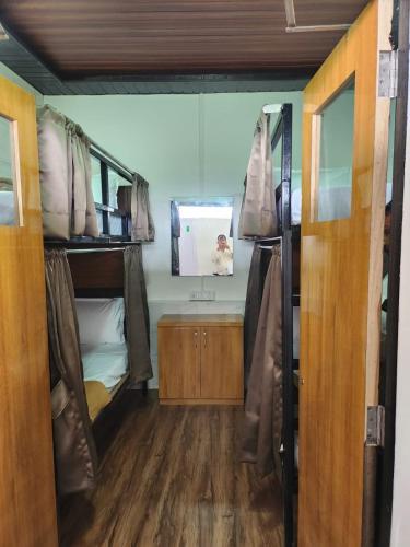 孟买Galaxy Cabin Stay And Dormitory的客房设有两张双层床和镜子