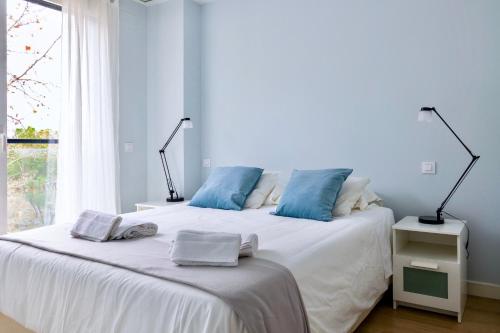 马德里Apart jardines San Vicente的一间卧室配有白色床和蓝色枕头