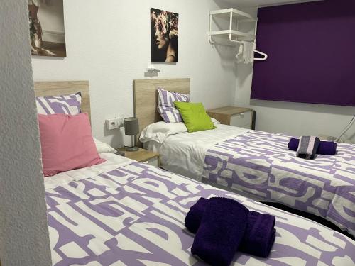 波多黎多德萨贡托艾尔巴赫芬酒店的紫绿色客房内的两张床
