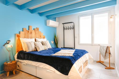 圣特罗让莱班chez Frederique的一间卧室设有一张蓝色天花板的大床