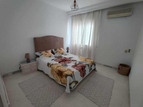 突尼斯Appartement Cozy aux Berges du Lac 1的一间卧室配有一张带花卉棉被的床
