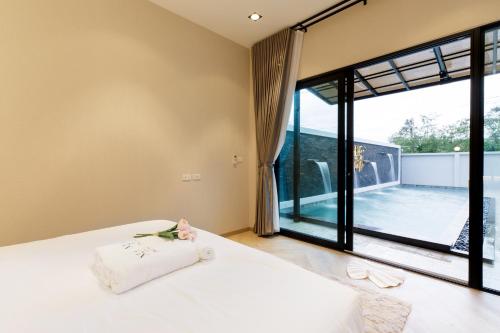 宋卡Nue Hatyai Pool Villa 147的一间卧室设有一张床和一个大窗户