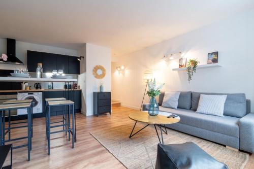 里尔Lille Grand Place - 1 bedroom apartment的客厅以及带沙发和桌子的厨房。