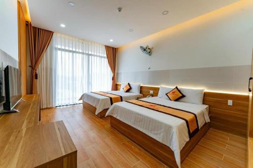 Tánh LinhKHÁCH SẠN HÀ PHƯƠNG的酒店客房设有两张床和一台平面电视。