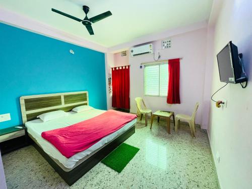 普里Sefali Beach Inn ! Puri - ViDi Group的一间卧室配有一张床、一台电视和一张桌子