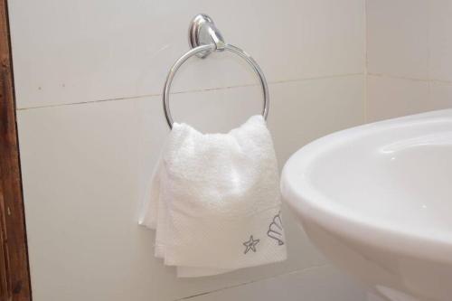 MeruMarvel Homes的洗涤槽旁毛巾架上的卫生纸卷