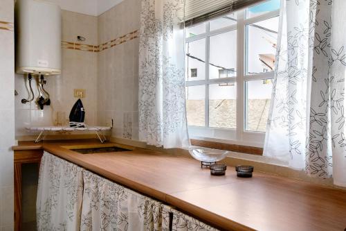 坎德拉里亚Casa Fefa的带水槽的厨房台面和窗户