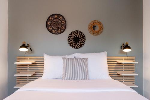 里尔Grand' Place of Lille - Superb designer apartment的卧室配有一张白色床,墙上挂着3个盘子