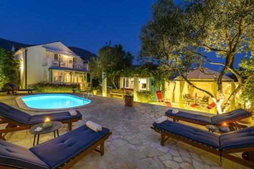 米利尼Villa Piano的一个带游泳池和房子的后院