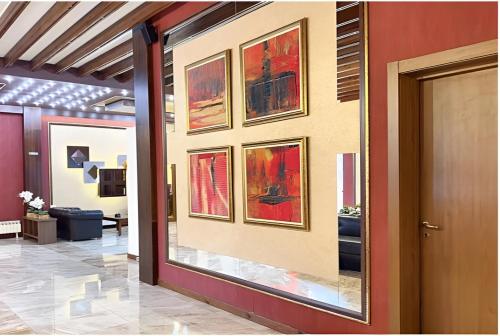 班斯科Platinum Hotel and Casino Bansko的建筑墙上的走廊上挂有绘画作品