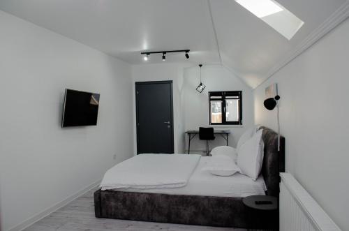 塔古玖PentGarden penthouse jacuzzi的一间白色卧室,配有一张床和一个黑色的门
