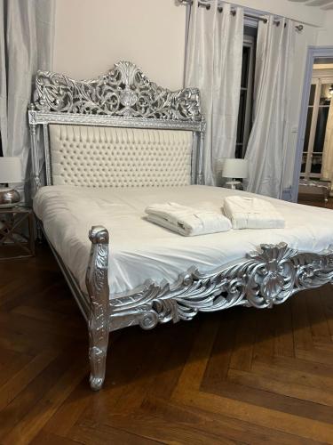La FouillouseChâteau Le Fournel的银色床,配有白色床单和枕头