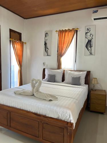 蓝梦岛Bima Homestay Lembongan的一间卧室配有一张大床,上面有天鹅