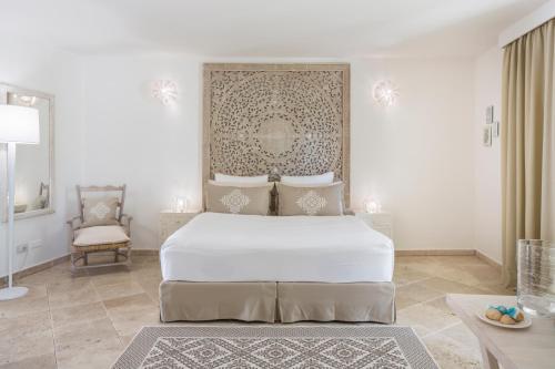 维拉西米乌斯卡波博伊法肯斯特诺度假酒店的白色卧室配有床和椅子