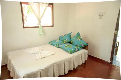 乌纳瓦图纳Mango villa的客房配有一张带蓝色枕头的床。