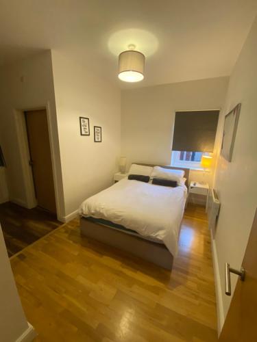 莱斯特Midland Apartments- one bedroom的卧室配有白色的床和灯