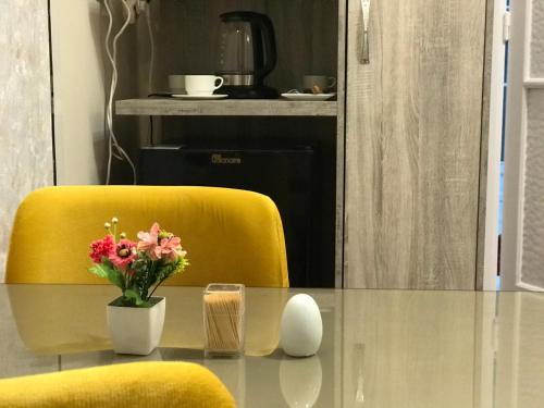 开罗Yacoubian Suites的花瓶和黄椅的桌子