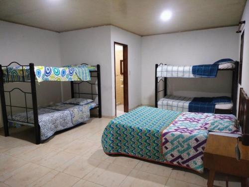 瓜杜阿斯El Vergel Guaduas的一间卧室设有两张双层床和一张桌子