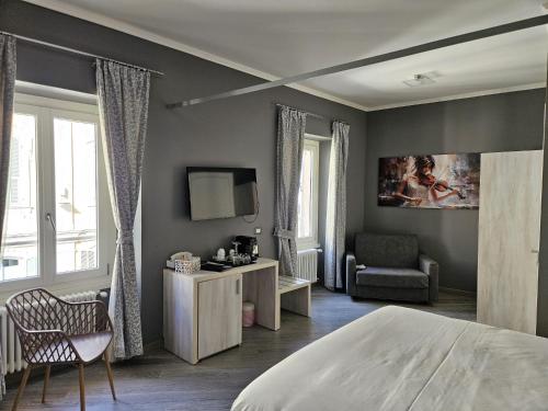 圣雷莫Primafila Premium Guest House的一间卧室配有一张床、一把椅子和电视。
