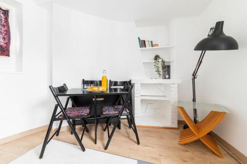巴黎Agréable studio cœur de paris - Paris 6 - 2P的一张带椅子和玻璃桌的黑色书桌