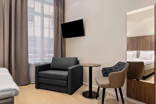 斯德哥尔摩卡勒普兰贝斯特韦斯特酒店的配有床、椅子和桌子的酒店客房