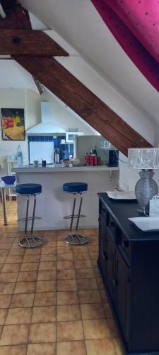 May-sur-OrneL'ABRI的一间厨房,里面配有两个蓝色的酒吧凳子