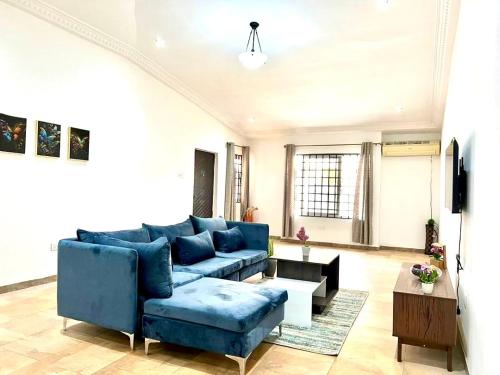OgbojoWyndham Villa的客厅配有蓝色的沙发和桌子