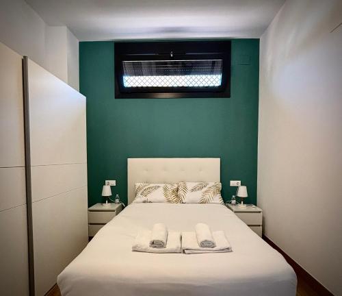 科尔多瓦Tabor的一间卧室配有一张床,上面有两条毛巾