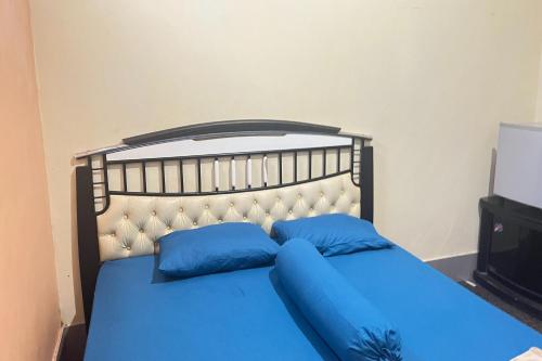 MamujuOYO 93416 Wisma Alam Syariah的卧室内的蓝色床和蓝色枕头