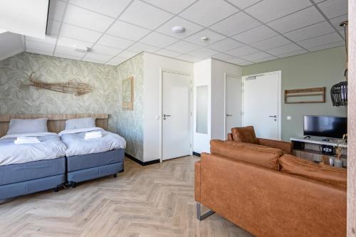 德科赫Strandplevier Suites的一间卧室配有一张床、一张沙发和一台电视。