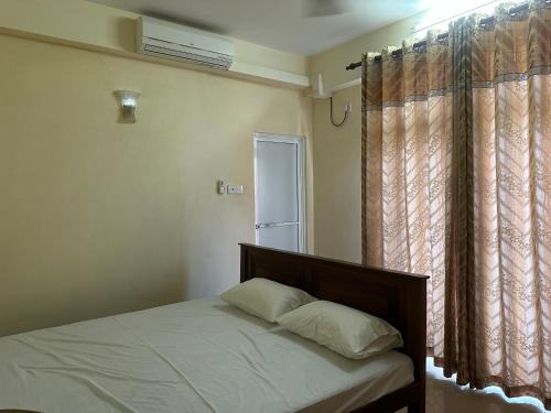 科伦坡Nexus 25的一间卧室配有床和带窗帘的窗户