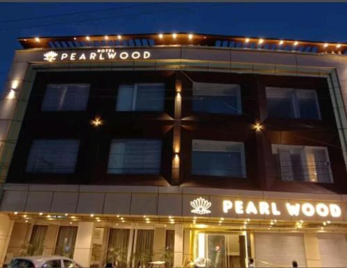齐拉克普尔HOTEL PEARL WOOD (A unit of olive hospitality group)的前面有标志的建筑