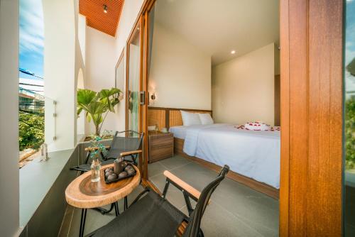 Ðông Tác (1)De V’Charm Hotel的卧室配有一张床和一张桌子及椅子