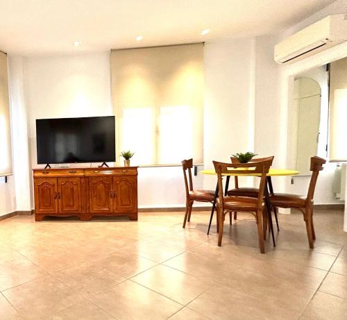 穆尔西亚Torre de Romo - Más que apartamentos的客厅配有桌子和平面电视。