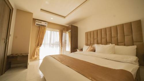 阿布贾The Seasons Apartment Kado的一间卧室设有一张大床和一个大窗户