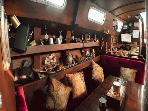 圣米格尔德阿沃纳The Captains Locker - 30ft Yacht的客房设有沙发和带枕头的桌子。