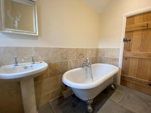 DonyattThe Udderhouse - Udderly Unforgettable Retreat的浴室设有水槽和镜子旁的浴缸