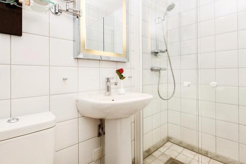 马尔默瑞典精英酒店的白色的浴室设有水槽和淋浴。