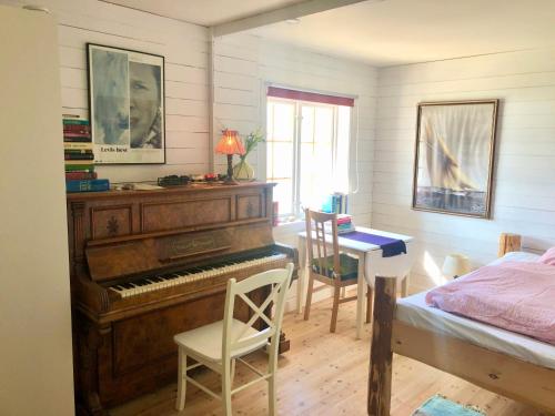 苏特兰House by the Sea的一间卧室配有钢琴、桌子和床