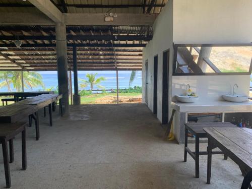 BurgosVilla Malinao Oceanview Resort - Deluxe bungalow的一间空餐厅,配有桌子,享有海景