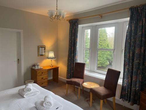 巴克斯顿威斯敏斯特酒店 的一间卧室配有一张床、两把椅子和一个窗户