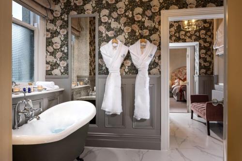 纳斯吉拉塞酒店的一间带浴缸的浴室和两件白色的衣服