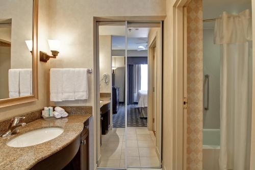 奥克维尔奥克维尔希尔顿惠庭套房酒店的浴室配有盥洗盆和步入式淋浴间。